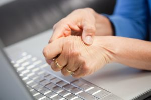 Laptop and woman with pain in hand